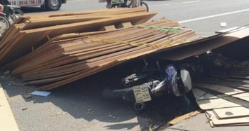 Kinh hãi hàng chục tấm ván từ xe container rơi đè trúng người đi xe máy