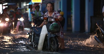 Người già hì hục đẩy xe trong triều cường dâng cao 1,6m ở Sài Gòn