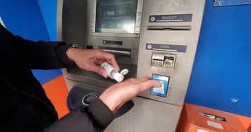 Khách rửa tay sát khuẩn trước khi vào cây ATM ở Hà Nội