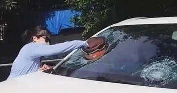 Người phụ nữ cầm mũ bảo hiểm hung hăng đập nát kính ô tô giữa phố