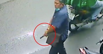 Hình ảnh người đàn ông cầm súng doạ 2 người phụ nữ.
